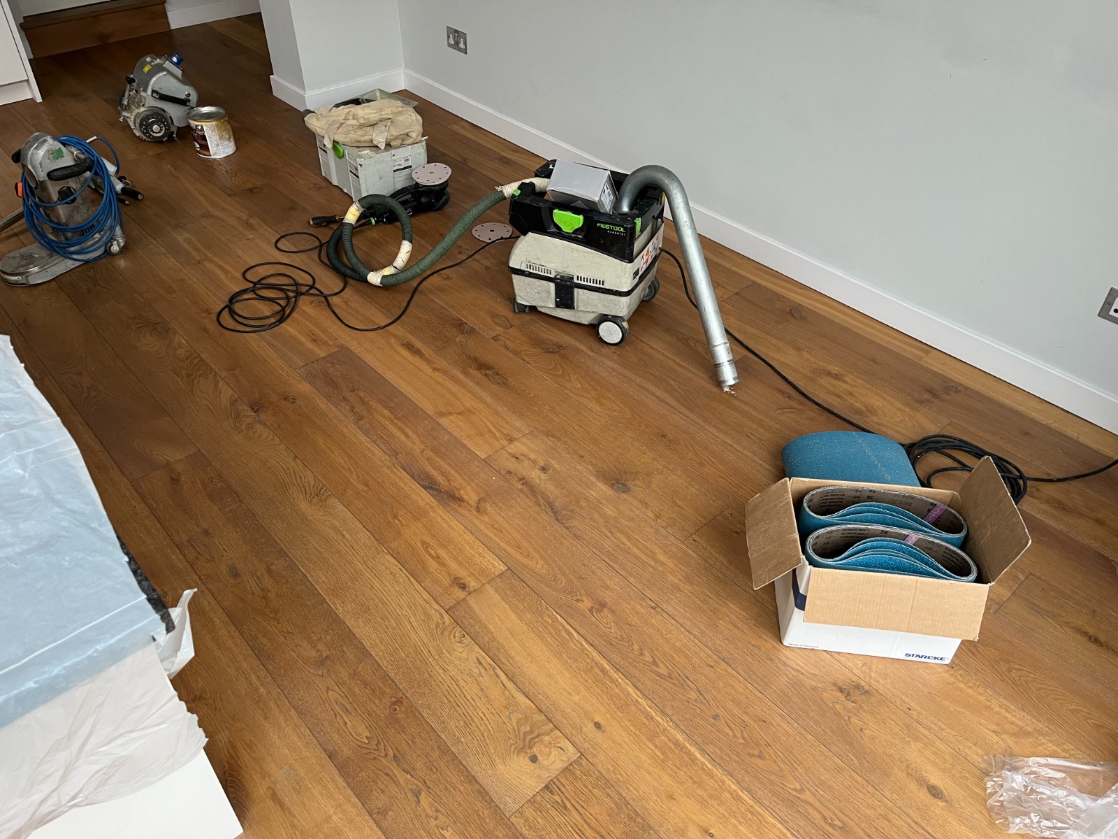Furious Fixes in Woking: prep set-up with sanding and dust-extraction equipment on an engineered European oak plank hardwood floor, ready for waxing and buffing.