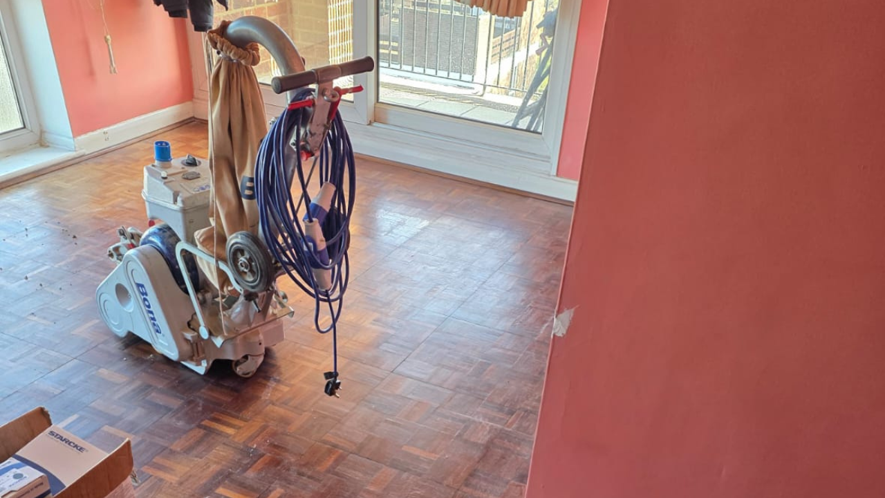 Wood Floor Sanding in Woking on an oak mosaic parquet living room floor using a professional Bona sanding machine.